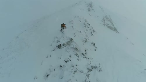 Mountain Climber Traversing a Snowy Rock Face
