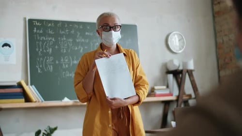 Teacher Giving Lesson to Student in Classroom