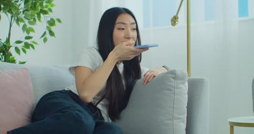 Young Woman Using Voice Assistant on Smartphone