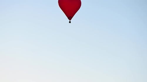 Red Heart Balloon Flies in Bright Blue Sky