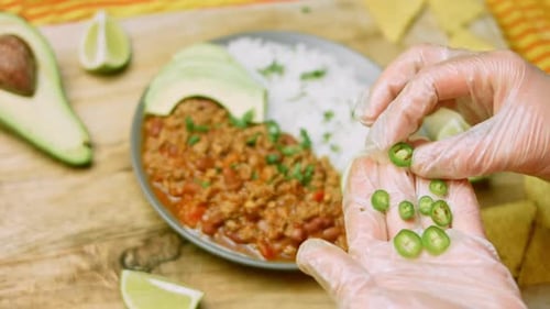 Garnishing Plate with Beans, Rice, and Avocado
