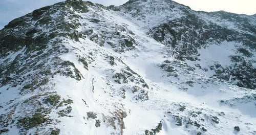 Seitenantenne über dem Winter Schneebedeckter Berg mit Bergsteigen Skifahrer Menschen beim Klettern