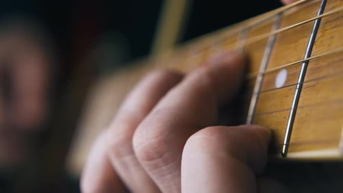 Professioneller Gitarrist spielt Ballade auf brauner Akustikgitarre