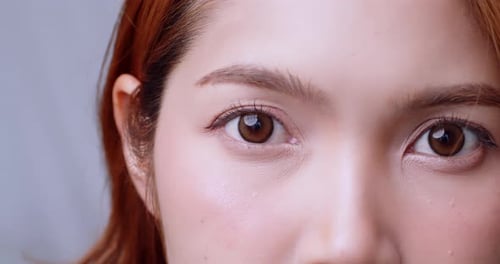 Close up of Positive human Asian woman eye and open looking at camera with happiness emotion attract