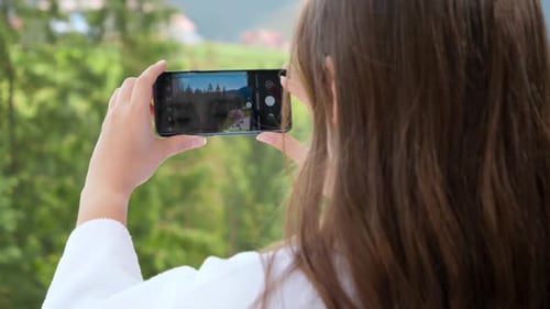 Young Woman Making Photographs of Beautiful Mountains and Pine Forest
