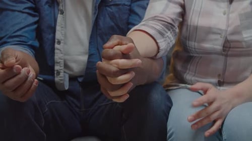 Diverse Couple Holding Hands in Loving Support