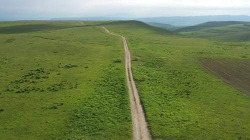 Beautiful summer landscape with Empty dirt road in the green valley