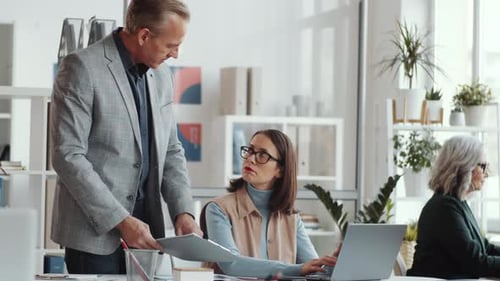 Businessman Discussing Job with Female Colleague in the Office