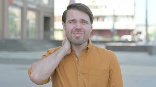 Young Man Experiencing Neck Pain Outdoors