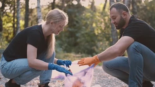 Two Volunteers Picking Up Trash and Rubbish in Their Community Park Not To Far From Their Home