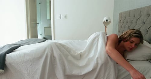 Woman Wakes Up and Stretches in Bedroom