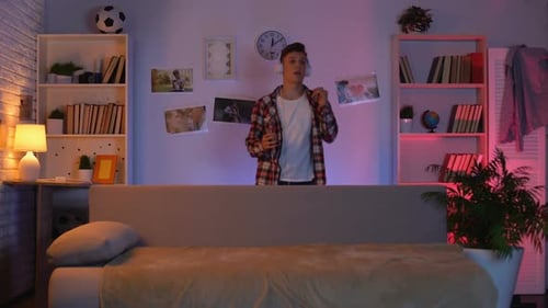 Adolescent dans des écouteurs écoutant de la musique et dansant, faisant semblant d'être célèbre