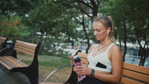 Close Up Portrait of Sportive Woman in Headphone Drinking Water After Workout