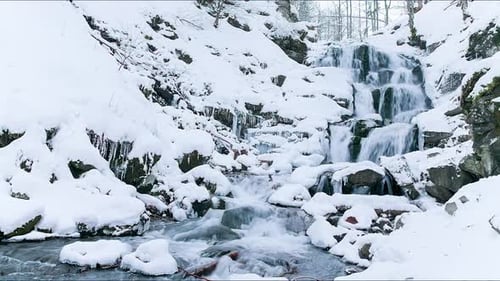 Wonderful Frozen Foot of a Waterfall with a Powerful Stream of Water at Winter Carpathian Mountains