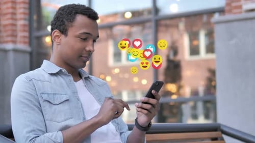 Hombre africano que usa smartphone Emoji Comentarios y me gusta