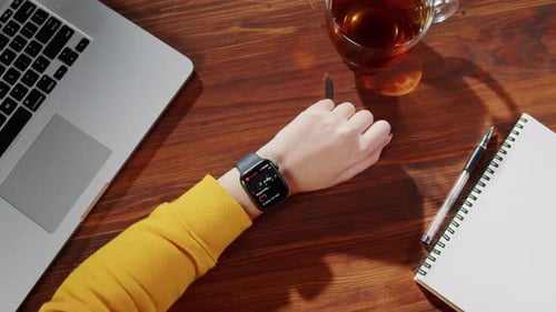 Woman at Desk Checks Activity Tracker Smartwatch
