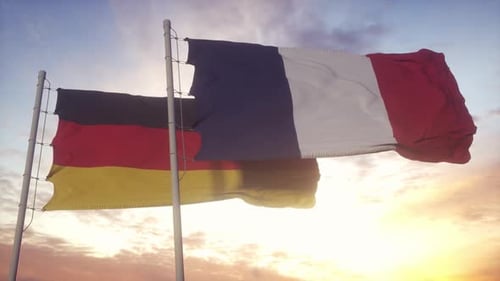 French and German Flags Waving in Golden Sunset Sky