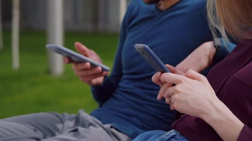 Cerrar vista con teléfonos inteligentes pareja joven, hombre y mujer sosteniendo teléfonos en las manos