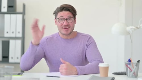 Adult Talks at Office Desk with Hand Gestures