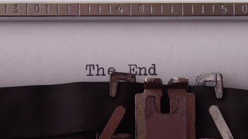 Typing phrase The End on retro typewriter. Close up.