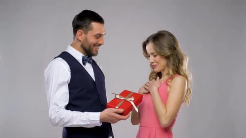 Happy Couple Exchanging Romantic Gift in Studio