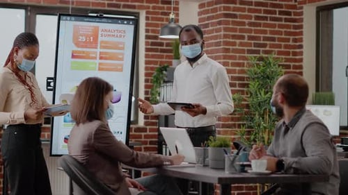 Team Analyzes Data with Masks in Modern Office
