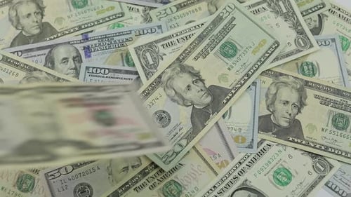 Dollar Bills Fall on the Table with American Dollars of Different Denominations