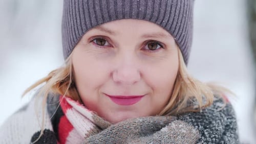 Young Woman's Face in Warm Scarf Against Snowcovered Park