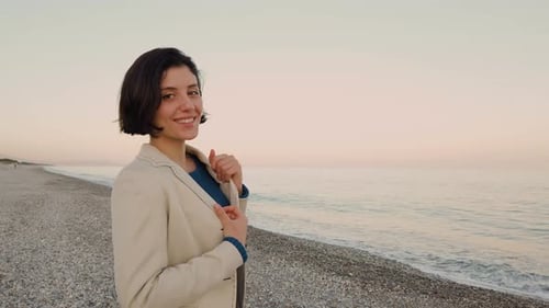 Beautiful Girl Walks at the Beach by the Ocean
