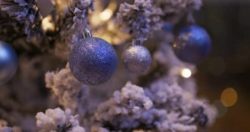 Glittering Ornaments on Snowy Christmas Tree