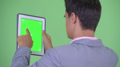 Closeup Rear View of Happy Young Businessman Using Digital Tablet