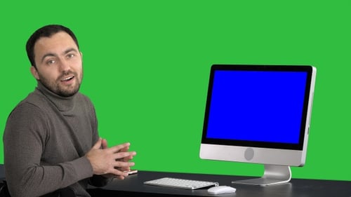 Man Talking Next to Computer on Green Screen