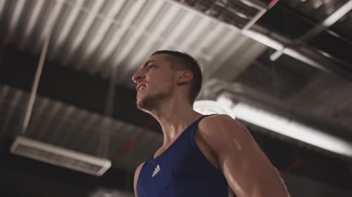 Man Lifts Dumbbell During Intense Workout