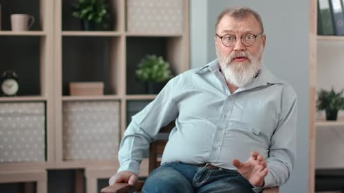Senior Man with Beard Talking While Sitting