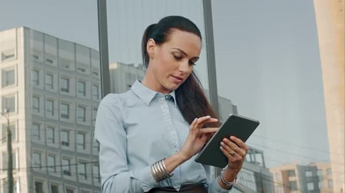 Businesswoman Working On Tablet Computer Outside Office