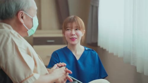 Asian beautiful nurse taking care of senior mature older male patient sit on wheelchair in hospital.