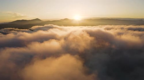 Vista aérea de drone do nascer do sol sobre as nuvens. Voando acima da névoa matinal nas montanhas.