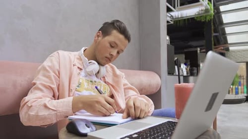 Young Adult Working on Laptop in Cafe