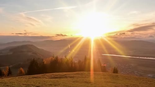 Schöner Sonnenaufgang über einer kleinen Stadt in der alpinen Berglandschaft am Herbstmorgen in Europa