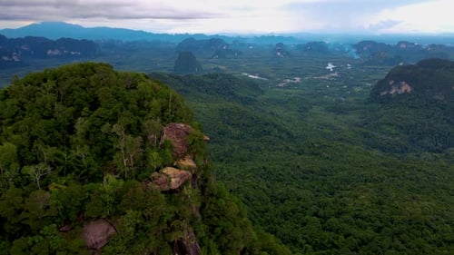 Dragon Crest Mountain Krabi Thaïlande un jeune voyageur est assis sur un rocher qui surplombe l'abîme avec un