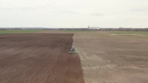 Tractor Plowing Field in Rural Landscape Aerial View