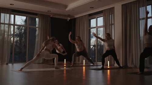 A Group of Women is Engaged in Stretching and Balance with an Instructor in a Beautiful Hall with