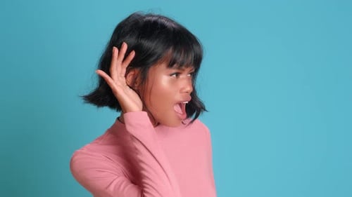Woman Puts Her Hand To Her Ear As a Sign of Attentive Listening or Eavesdropping