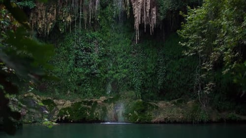 Große Wasserfalltropfen fallen von der Klippe in ruhiges Seewasser