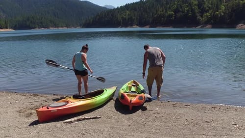 Couple getting ready to kayak at lake