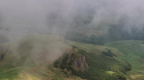 Misty rocky mountains surrounded by big thick fog