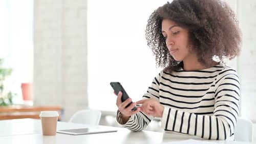 Woman Using Smartphone Device in Bright, Modern Setting