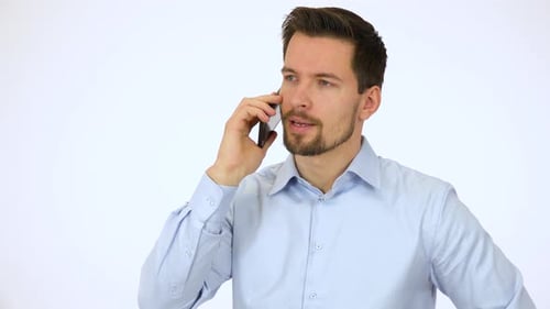 Un jeune homme beau parle sérieusement sur un smartphone - White Screen Studio