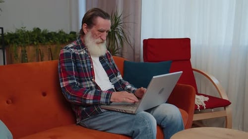 Mature Man Using Laptop Computer Indoors