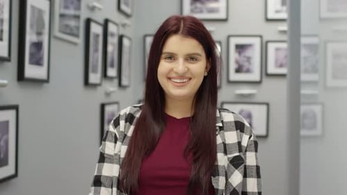 Smiling Woman with Auburn Hair in Indoor Setting